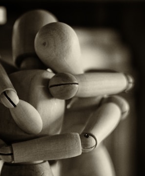 two wooden dummy hugging figures