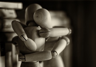 two wooden dummy hugging figures