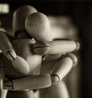 two wooden dummy hugging figures