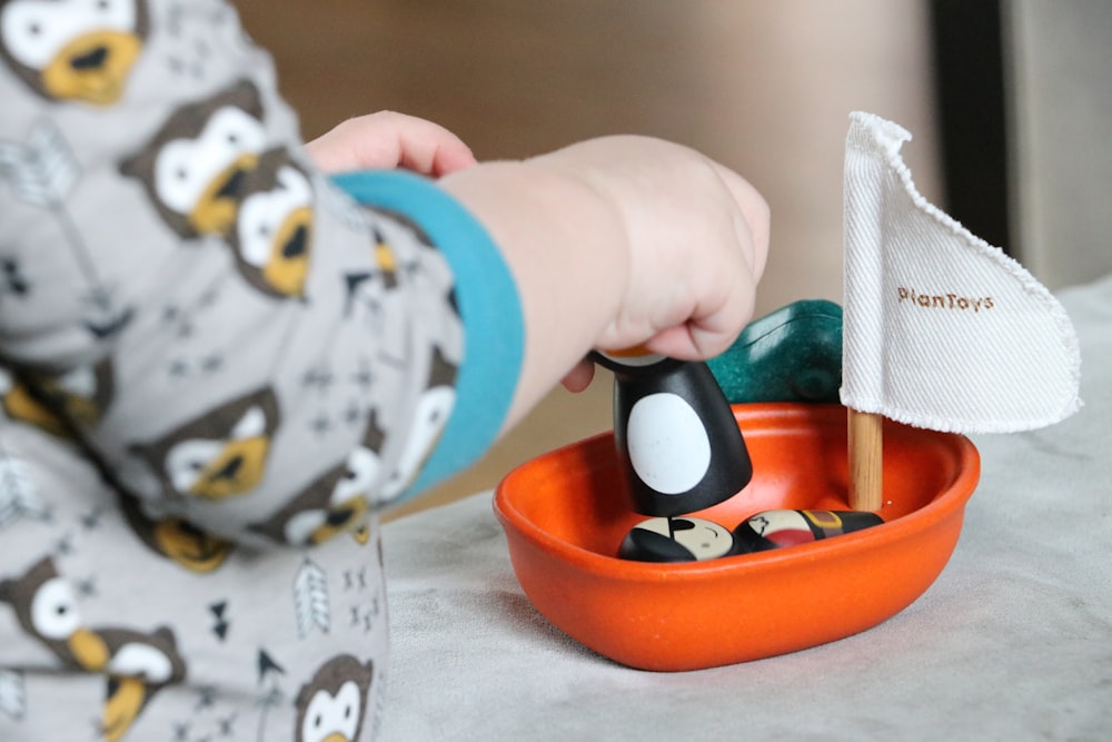 マットレスの上でプラスチックボートで遊ぶ幼児