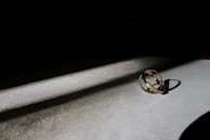 Softly lit image of intertwined silver and gold rings symbolizing union.