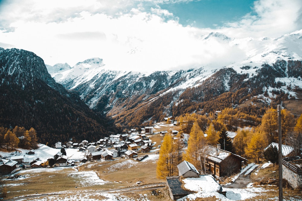 a mountain village surrounded by snow covered mountains