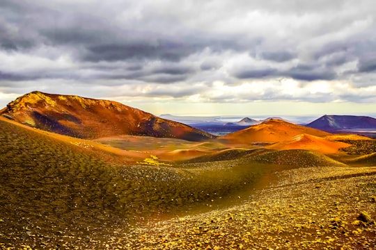 grass and soil covered field and mountains in Lanzarote Spain