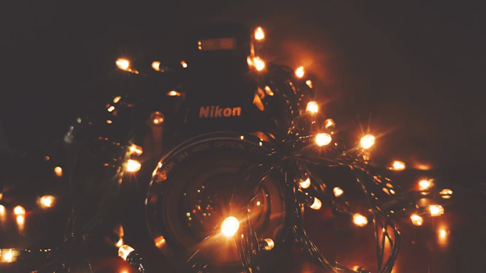 A softly lit studio scene with a vintage camera and warm fairy lights creating an inviting atmosphere.