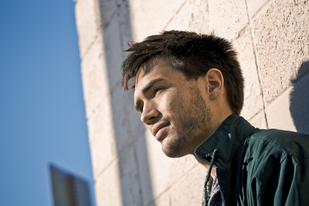 man leaning on concrete wall