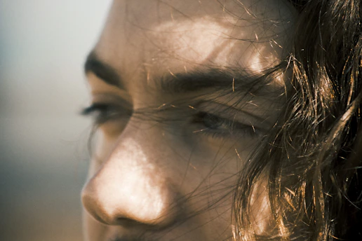 Close-up of a dewy, radiant face glowing naturally in soft morning light.