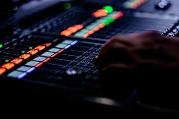 person's hand on black audio mixer