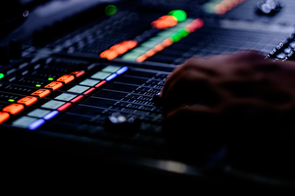 person's hand on black audio mixer