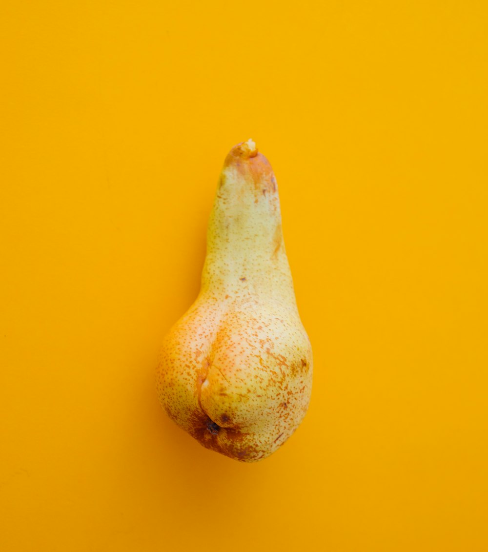 una pera su uno sfondo giallo brillante