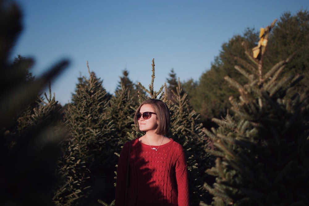 woman standing surrounded by green trees