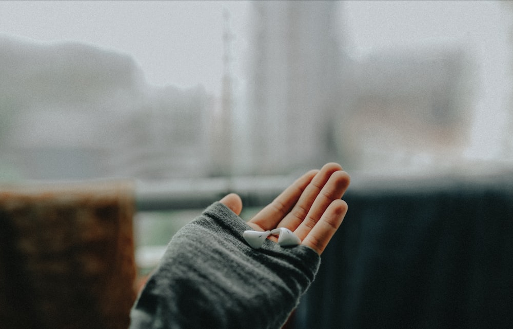 La mano de la persona izquierda sosteniendo los auriculares