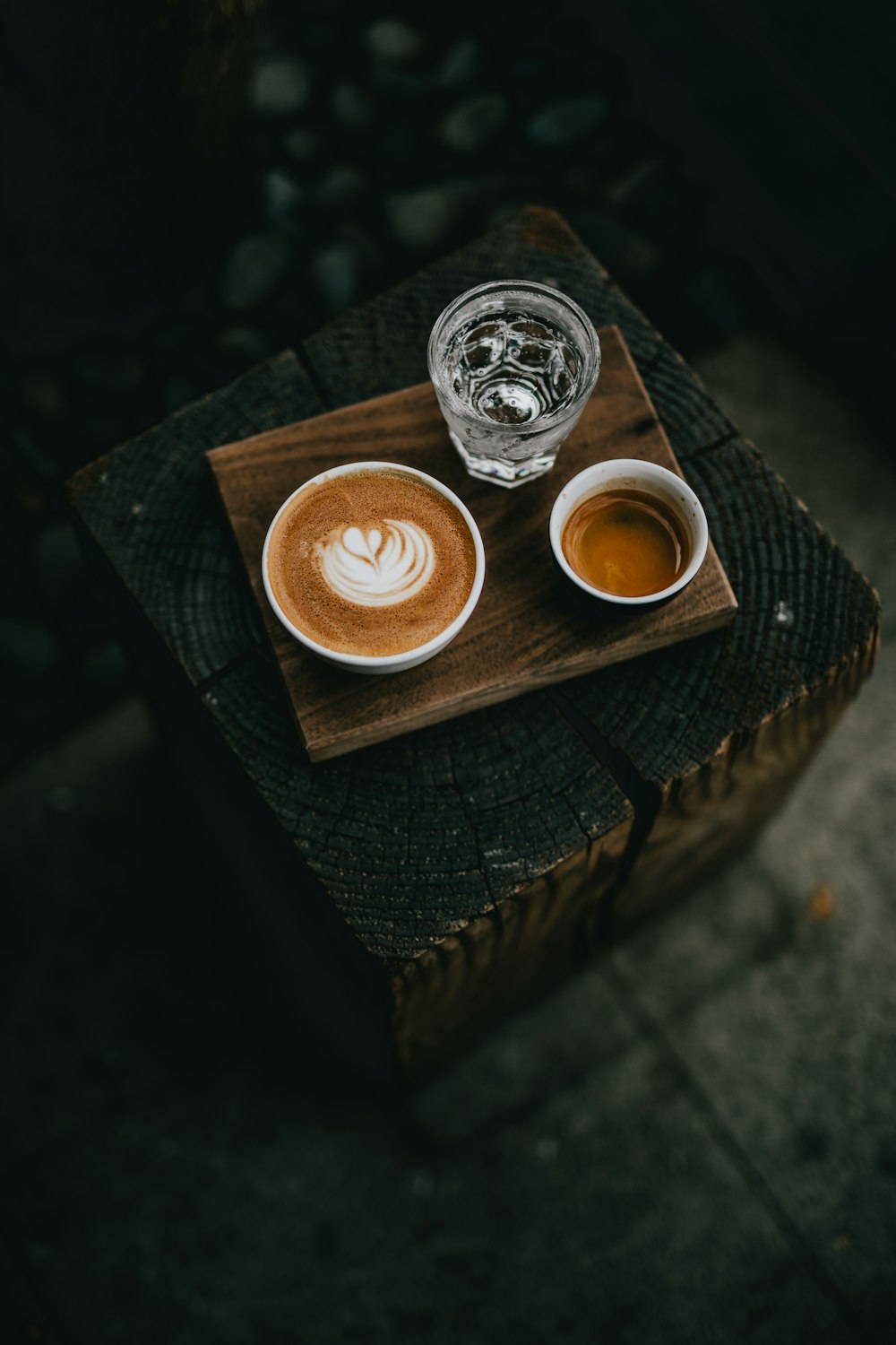 weiße Keramiktasse gefüllt mit Kaffee neben einem Glas Wasser