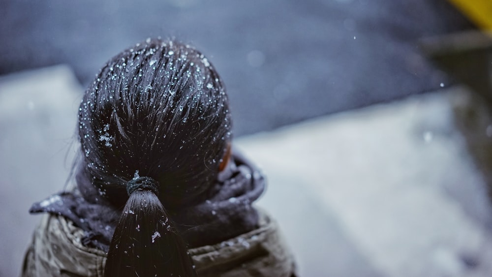Mise au point sélective d’une personne avec des gouttelettes de neige sur les cheveux