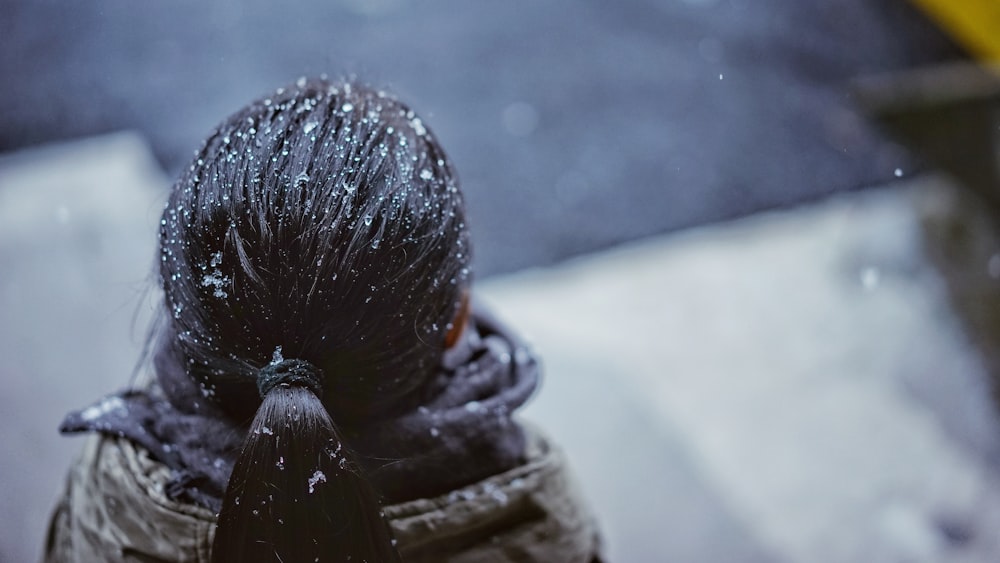 messa a fuoco selettiva della persona con le gocce di neve sui capelli