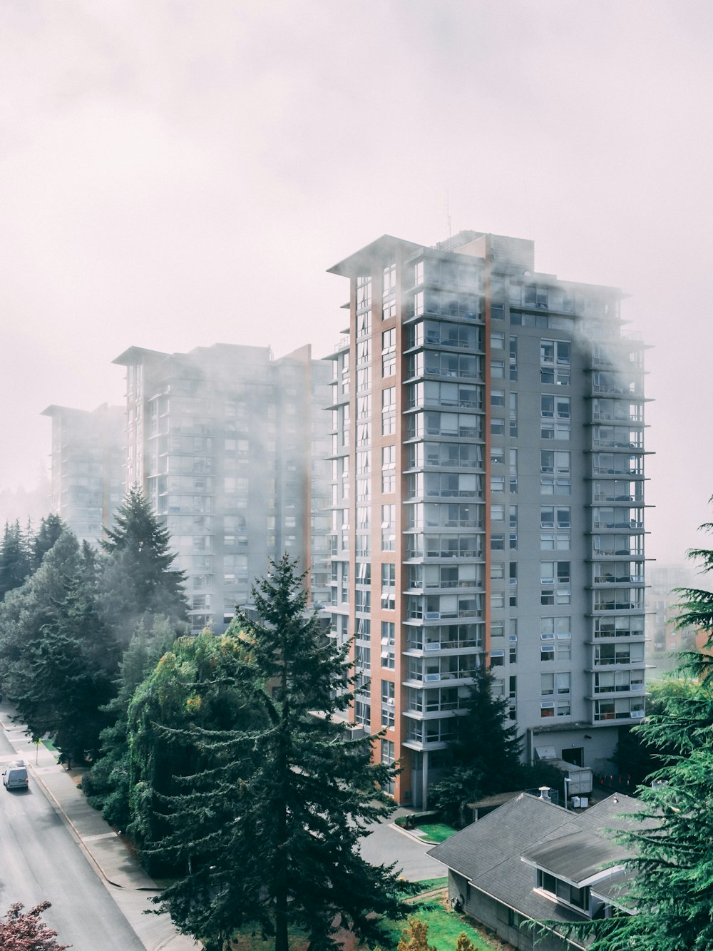 Edificio grigio e marrone con tempo nebbioso durante il giorno