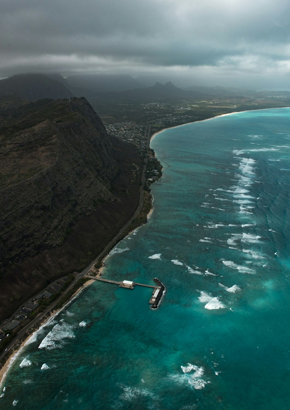 aerial photo of beach dock near cliff