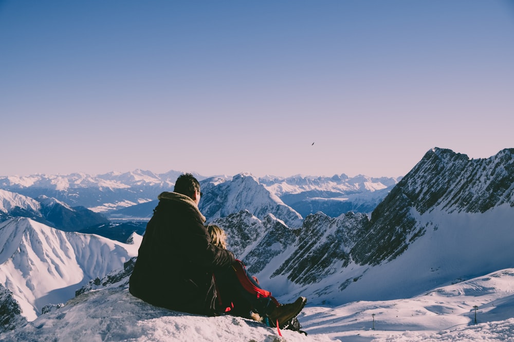 man and woman on top of peak