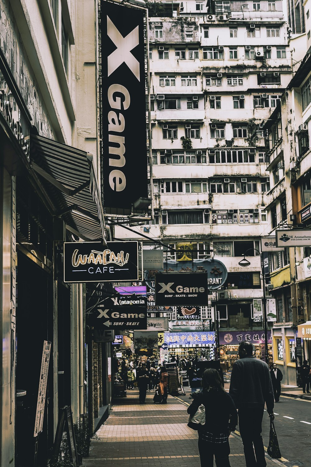 man and woman walking along sidewalk of city building