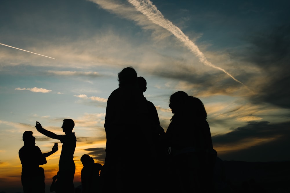 Fotografia della silhouette della gente sotto il cielo