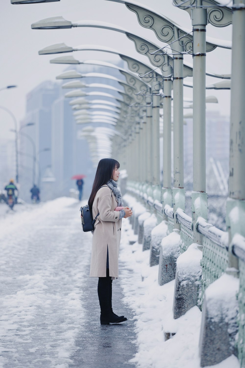 woman standing on bridge facing railings