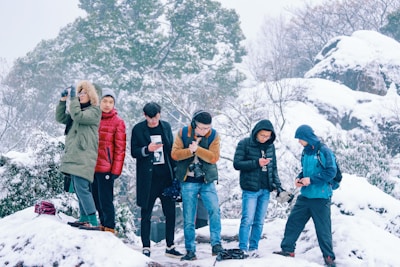 A group of friends checking the ski lease manager app on an iPhone while standing outside in ski gear.
