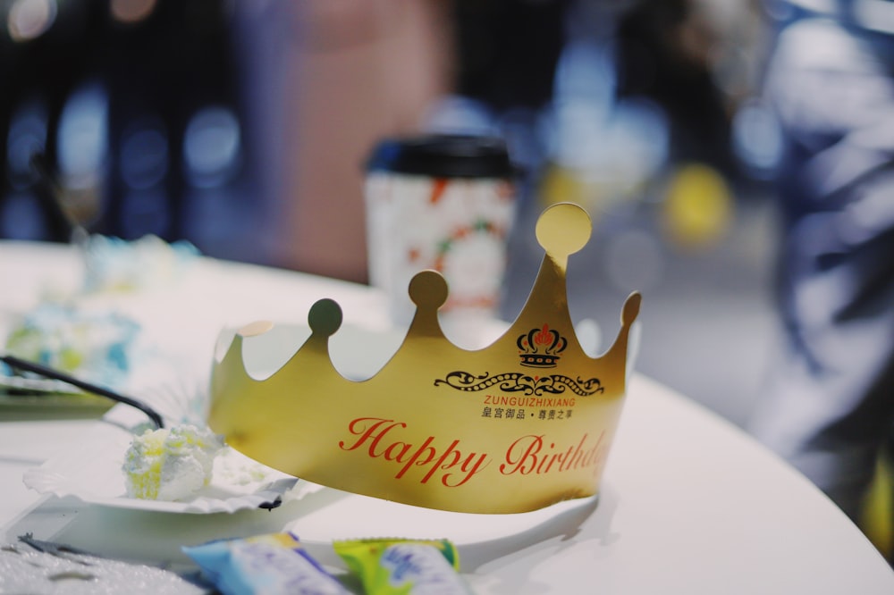 tilt shift lens photography of gold paper crown on top of white wooden table