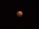 A celestial event captures the Earth's shadow covering the moon, giving it a reddish hue known as a blood moon, set against a black night sky.
