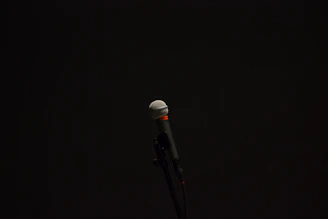 Microphone on stage with a spotlight highlighting its metallic surface