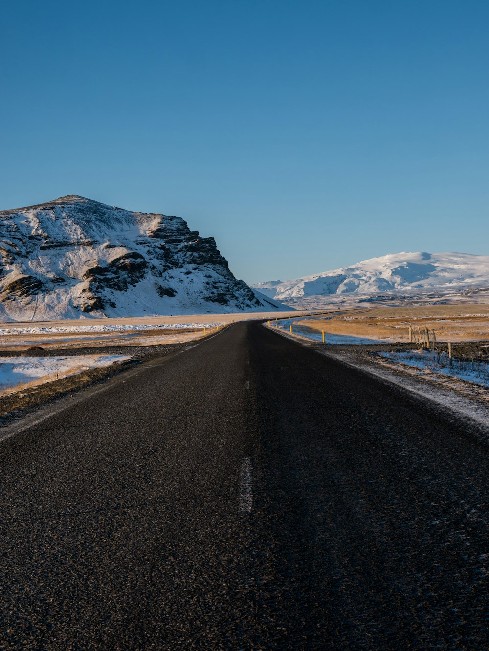 empty concrete road with snow capped mountain background