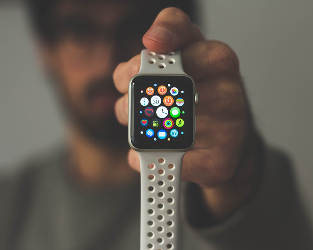 Someone holding a refurbished apple watch at arms length showing the screen