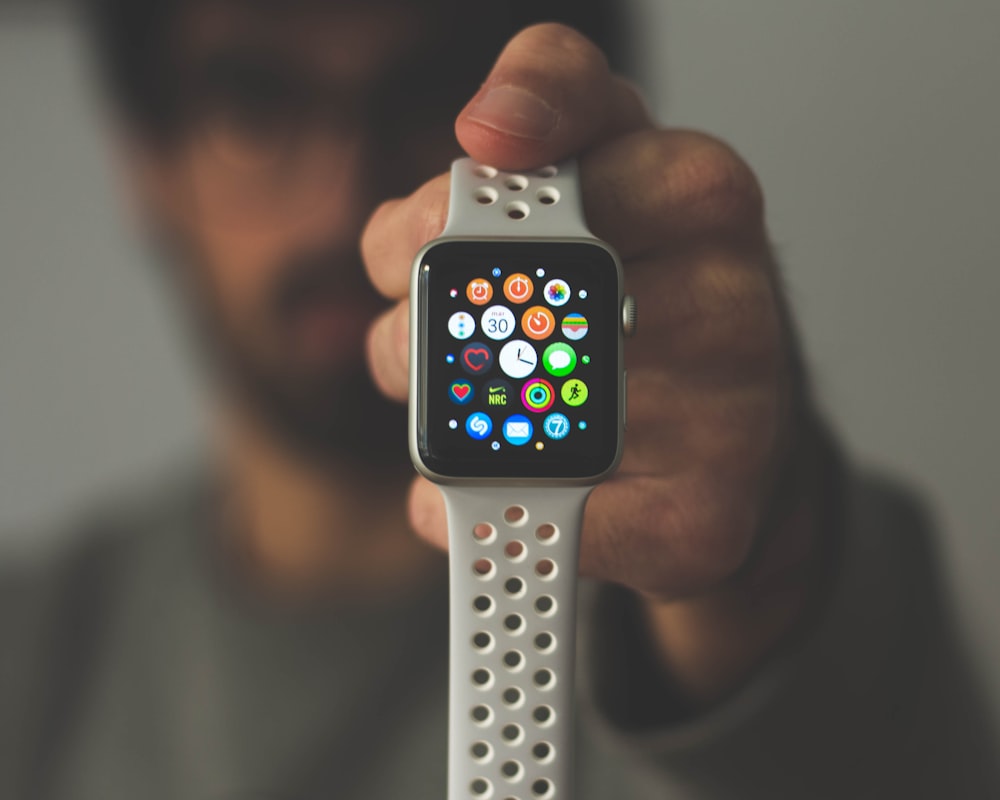 persona che tiene in mano una custodia in alluminio argentato Apple Watch
