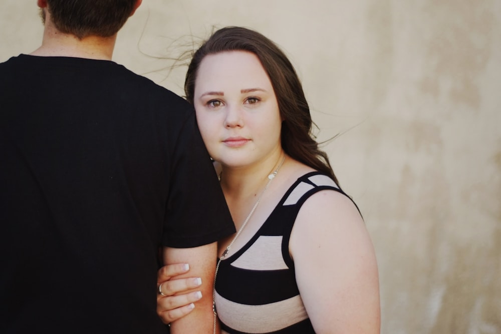 woman hugging man's arm