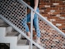 woman walking on stair near railling and wall