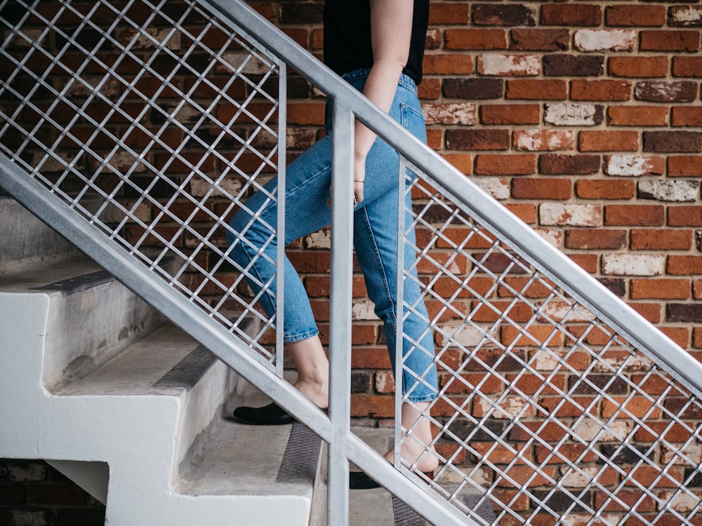 woman walking on stair near railling and wall