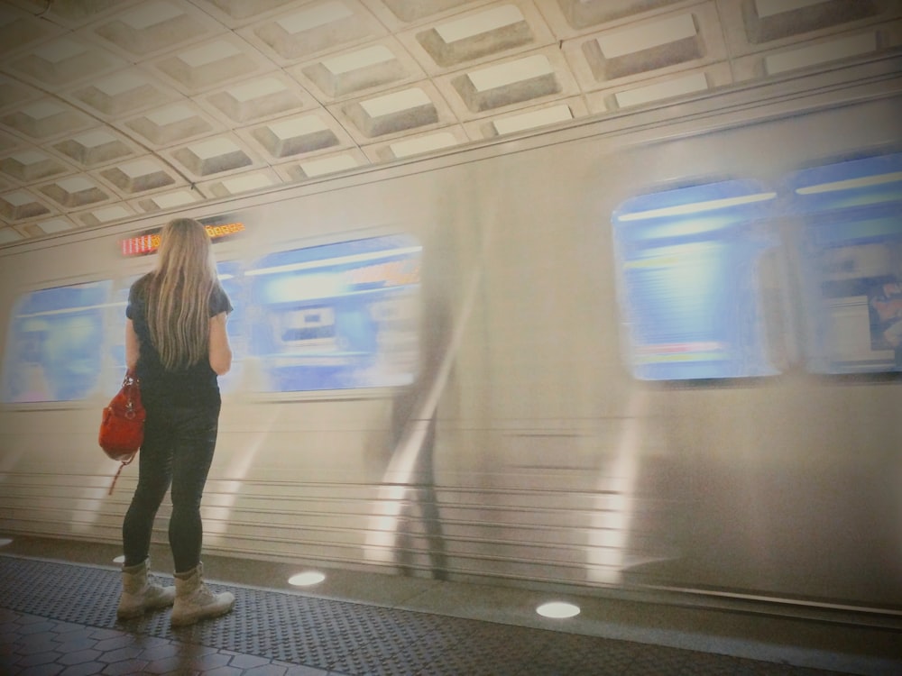 a woman waiting for a train at a train station