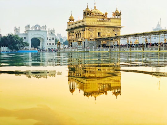 yellow temple near body of water in Harmandir Sahib India