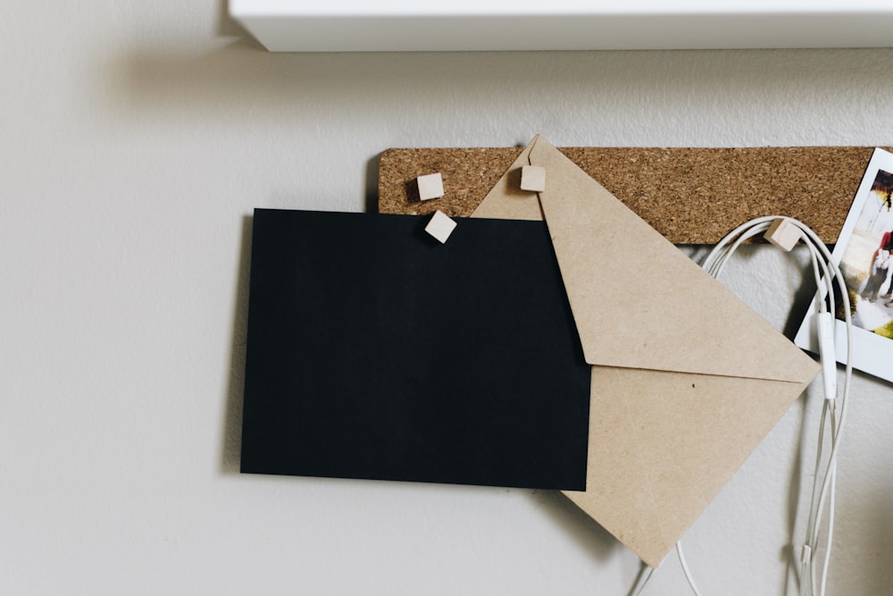 black and brown envelopes on cork board