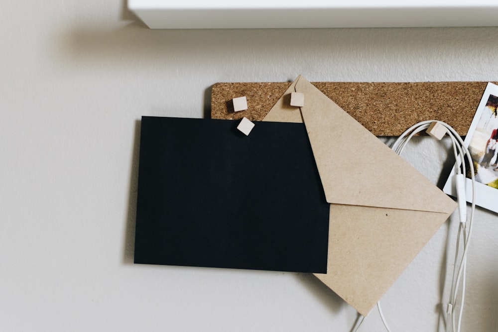 Envelopes pretos e castanhos em placa de cortiça