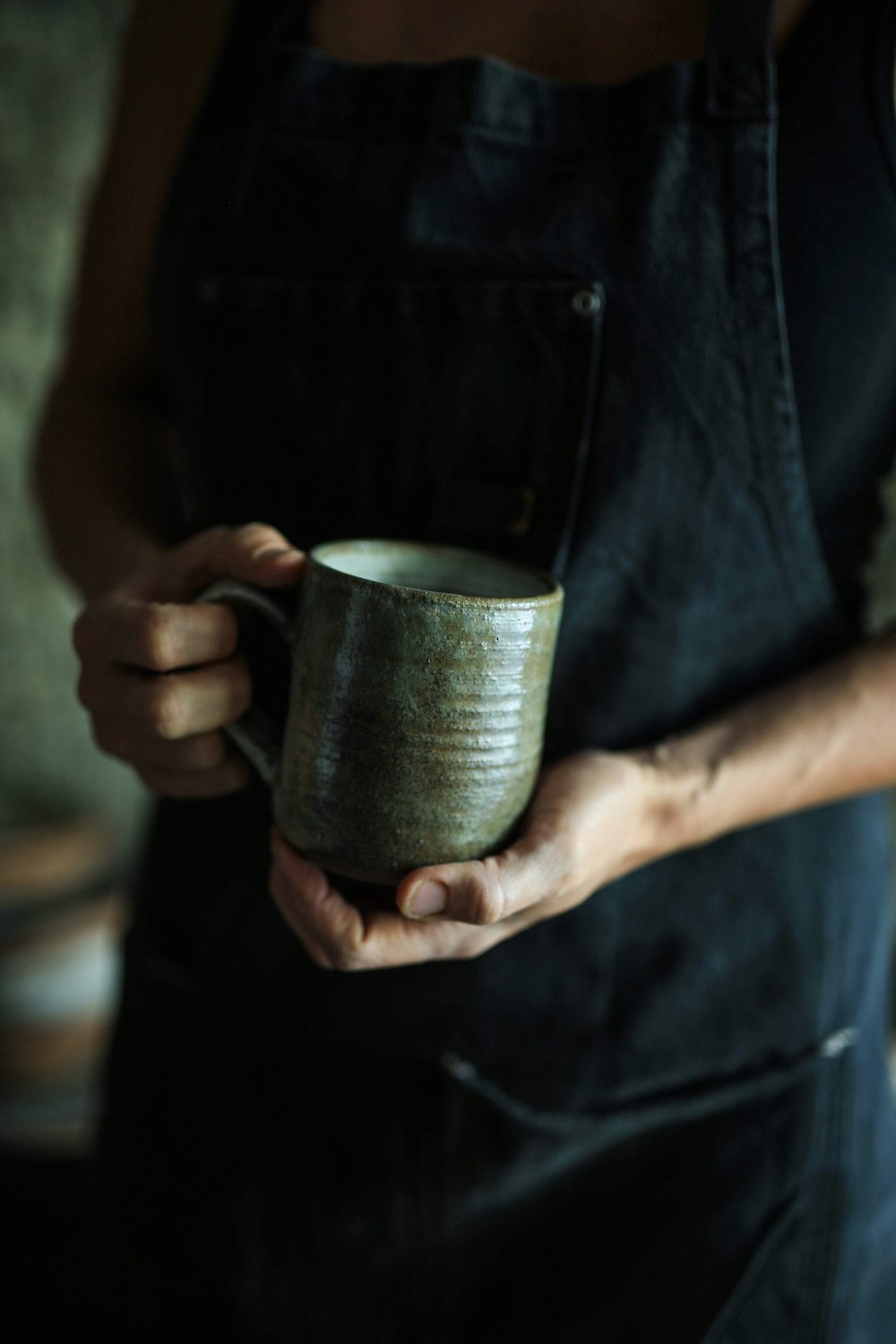 persona sosteniendo una taza de cerámica