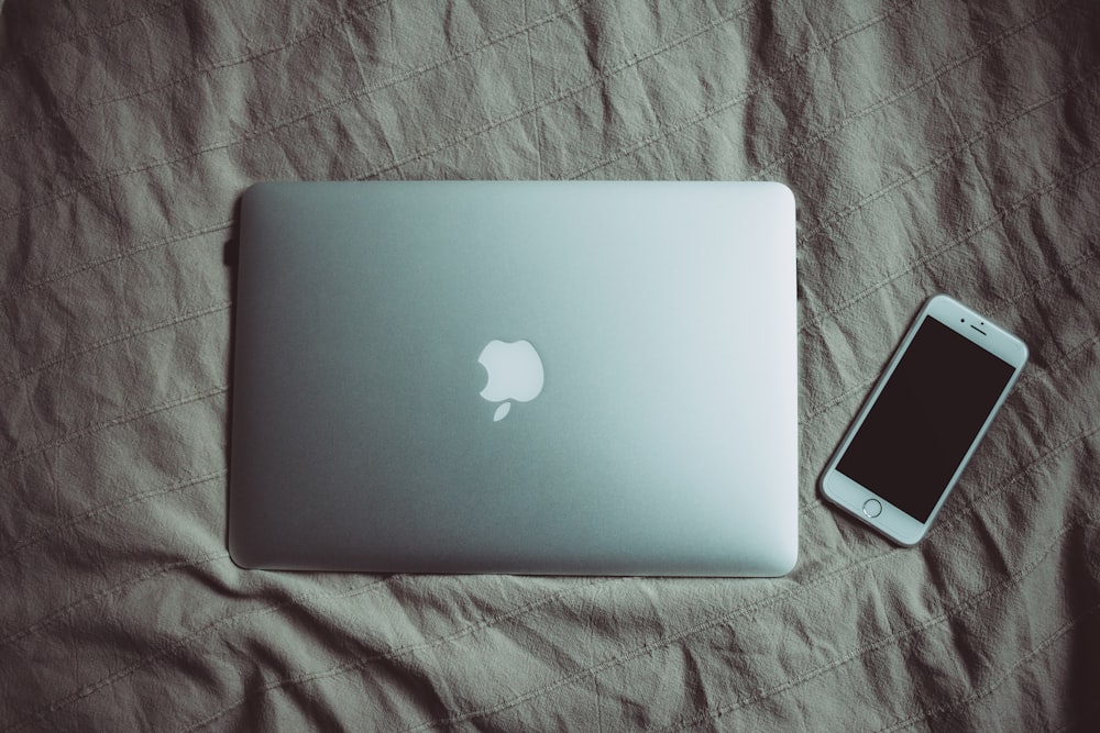 silver MacBook beside post-2014 iPhone