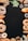 An assortment of baked goods, including bread, croissants, donuts, and pretzels, is arranged around the borders of a dark background. There are decorative elements such as green leaves and a small cup of coffee beans. The breads have different shapes, textures, and some are topped with seeds.
