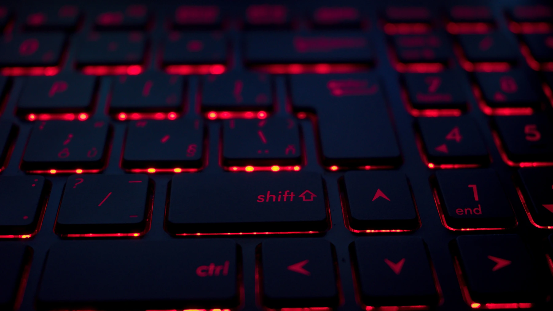 A laptop screen illuminating a dark workspace.