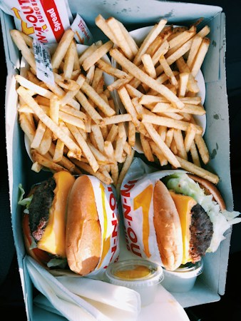 Burgers and fries packed in a takeout box, showing the food-with-drink takeout order Las Vegas now allows under its to-go alcohol rules