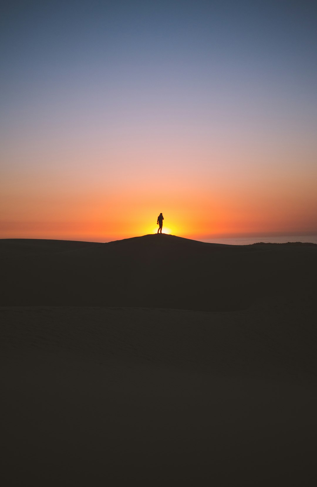 silhouette of person standing on hill