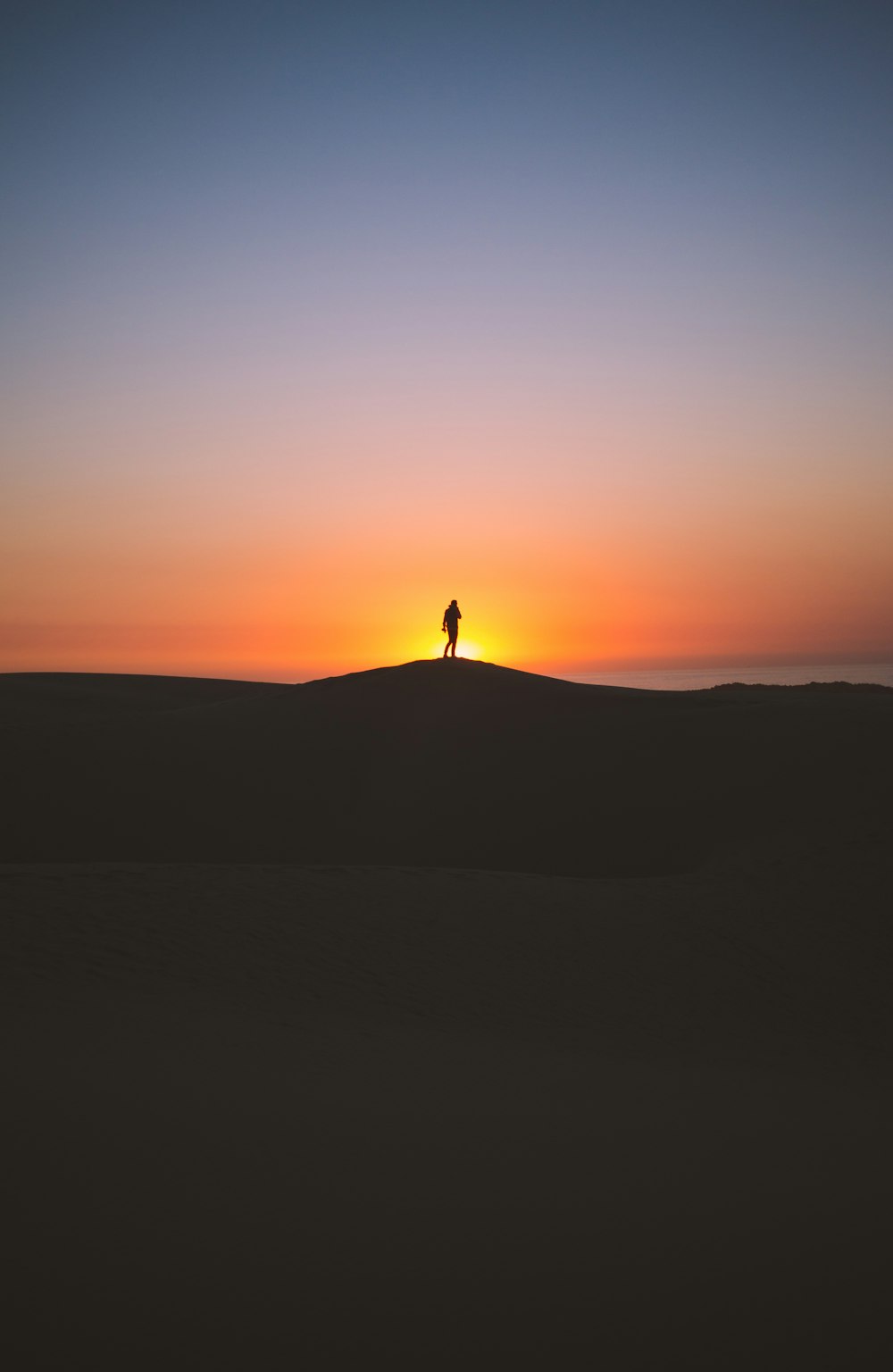 silhouette of person standing on hill