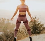 woman jumping above gray sand