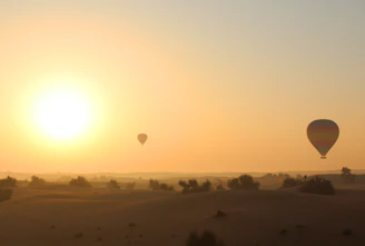 Documentary-style photo capturing a serene desert sunrise with soft pinks, purples, and blues, participants enjoying a yoga session on a sandy plateau.