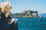 Island shoreline with temples dotting the hills, viewed from the ferry window.