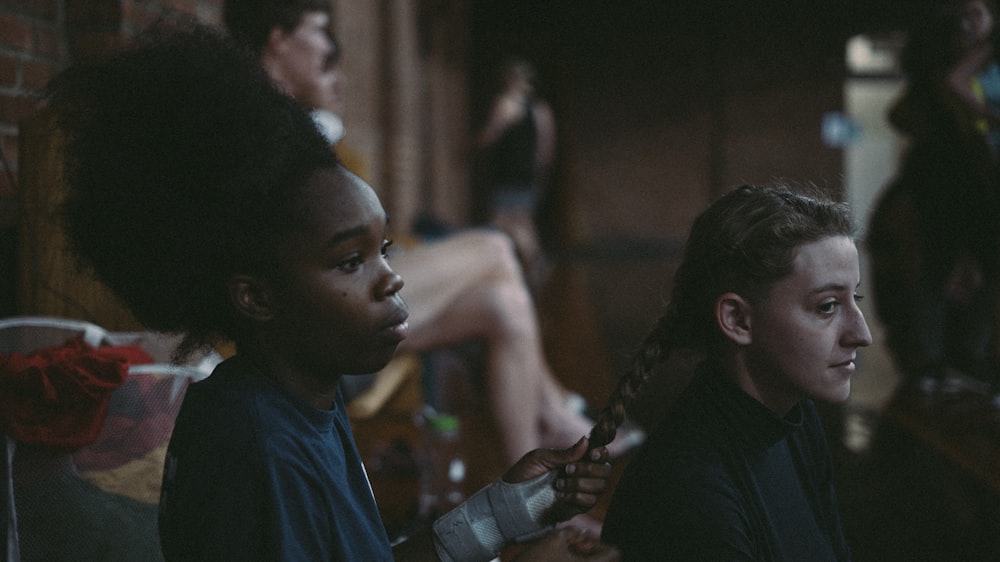 woman sitting on chair holding braided hair