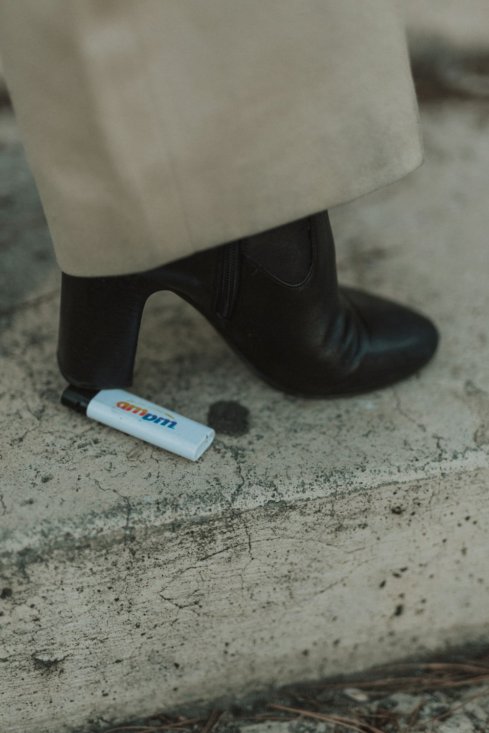 person stepping on white disposable lighter